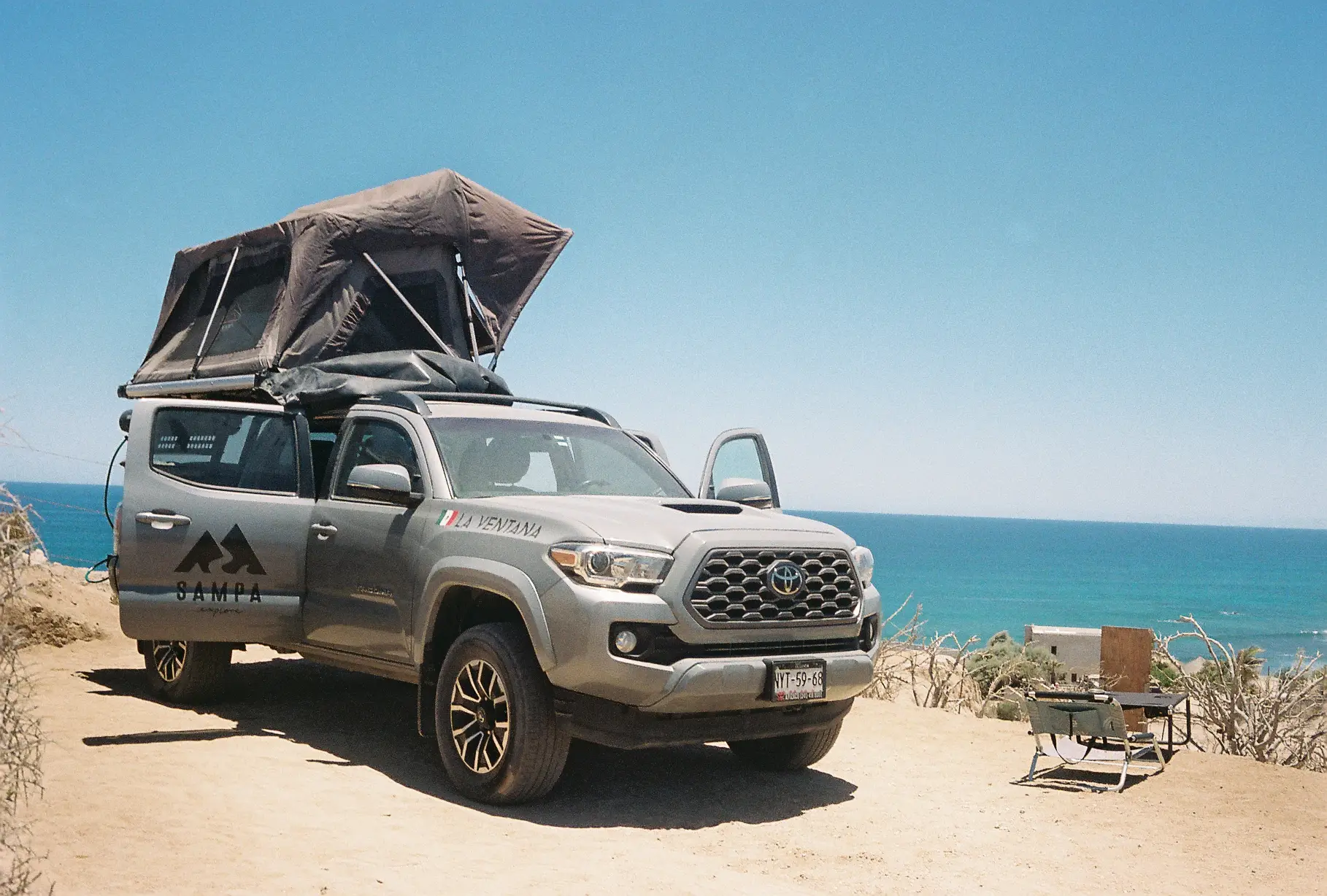 Truck with a rooftop tent at an ocean view campsite at ALAIA Surf Lodge